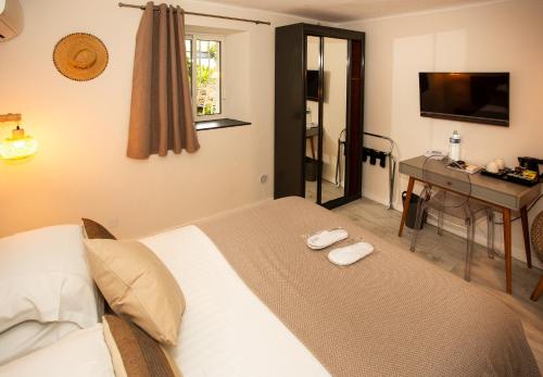 a bedroom with a bed and a desk and a television at Villa Claudia Hotel Cannes Centre - Parking in Cannes