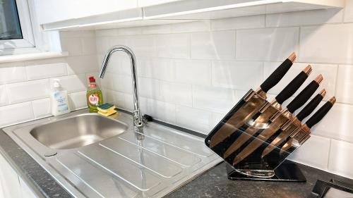 a kitchen counter with a knife rack next to a sink at Charming apartment with a small garden in Finsbury Park in London