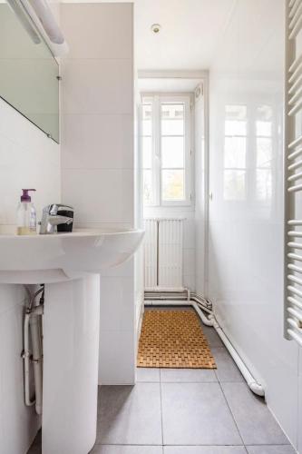 a white bathroom with a sink and a mirror at Maison Briand - Grande chambre chez l'habitant - Melun Centre - Wifi, Netflix, Smart TV, Lit à mousse mémoire de forme in Melun
