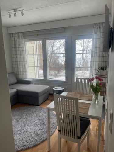 ein Wohnzimmer mit einem Tisch und einem Sofa in der Unterkunft Yksiö Pispalassa in Tampere