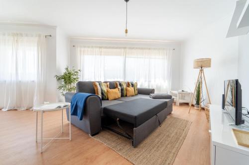 a living room with a couch and a tv at Beach Flat by House and People in Viana do Castelo