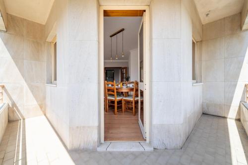 an open door to a dining room with a table at Beach Flat by House and People in Viana do Castelo