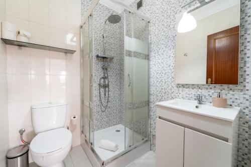 a bathroom with a toilet and a shower and a sink at Beach Flat by House and People in Viana do Castelo