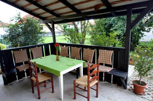 Kmečka hiša Rodica في دومزالي: طاولة خضراء وكراسي على الفناء
