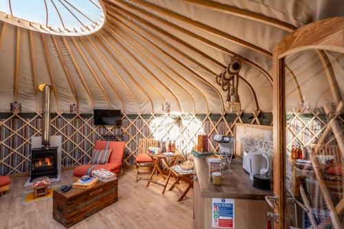 a yurt with a kitchen and a living room at Glamping at South Lytchett Manor in Poole
