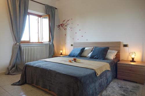 een slaapkamer met een bed met blauwe lakens en een raam bij Reggia di Venaria - Tranquillity choice - Parcheggio gratuito - Grand Maison in Venaria Reale