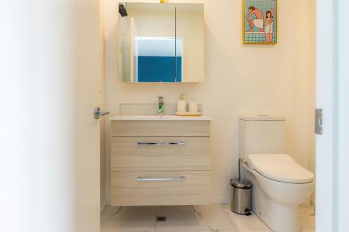 a bathroom with a toilet and a sink and a mirror at stylish and comfort in CBD in Christchurch