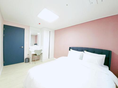 群山的住宿－Gunsan Little Prince Condo，一间卧室设有一张大床和一扇蓝色的门