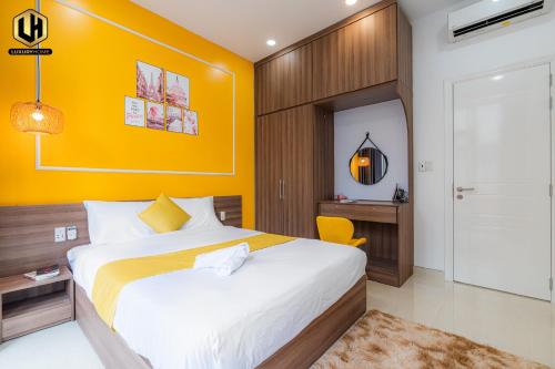 a bedroom with a bed and a yellow wall at Luxury Condotel Sai Gon 2 in Ho Chi Minh City