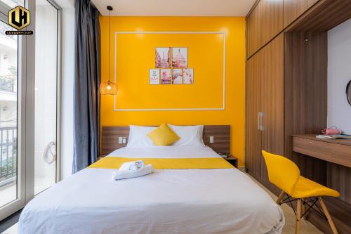 a bedroom with a bed and a yellow wall at Luxury Condotel Sai Gon 2 in Ho Chi Minh City