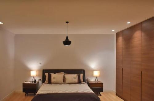 een slaapkamer met een groot bed met 2 nachtkastjes bij Longacers place in Lusaka