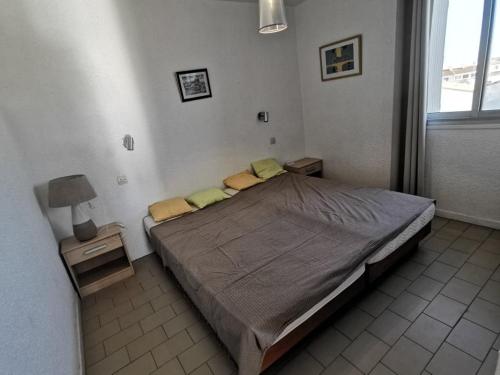 une chambre avec un lit avec deux tables de nuit et une fenêtre dans l'établissement 006 Palmeraie B17, au Cap d'Agde