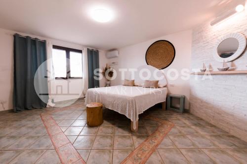 Schlafzimmer mit einem Bett und einem Wandspiegel in der Unterkunft Be Nature in Porto Cesareo