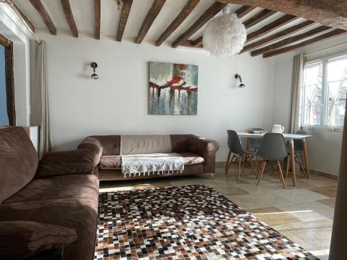 un salon avec un canapé et une table dans l'établissement La Chapelle de Monet - Logis Coquelicots, à Bois-Jérôme-Saint-Ouen