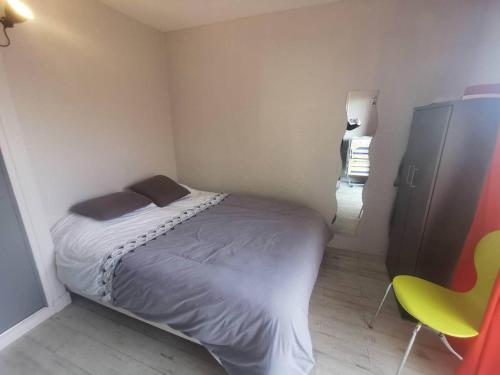 une petite chambre avec un lit et une chaise jaune dans l'établissement 069 Criques 301, au Cap d'Agde