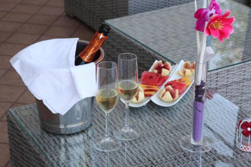 a table with two glasses of wine and a plate of food at Tenuta Terre di Bosco Oasi di Relax nel Cilento in San Giovanni a Piro