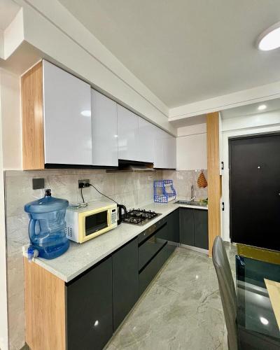 a kitchen with white cabinets and a microwave on a counter at Easy spacious apartments in Durban