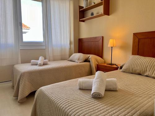 Cette chambre comprend 2 lits et une fenêtre. dans l'établissement Apartamento Somo Puerto, à Somo
