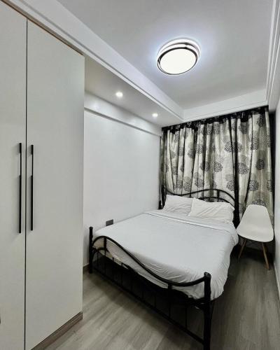 a small bedroom with a bed and a window at Easy spacious apartments in Durban