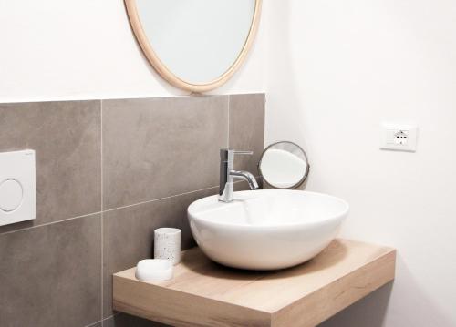 a bathroom with a white sink and a mirror at I Marmi New Royal Design Apartment in Livorno
