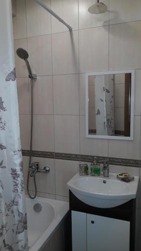 a white bathroom with a sink and a shower at Green Park District cosy apartment in Rīga