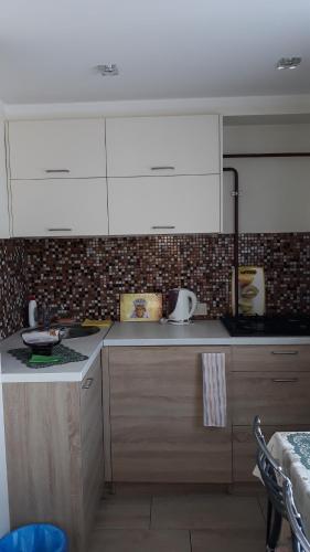 cocina con armarios blancos y encimera en Green Park District cosy apartment, en Riga