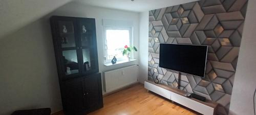 a living room with a flat screen tv on a wall at Ferienwohnung Elisabeth Waxweiler in Waxweiler