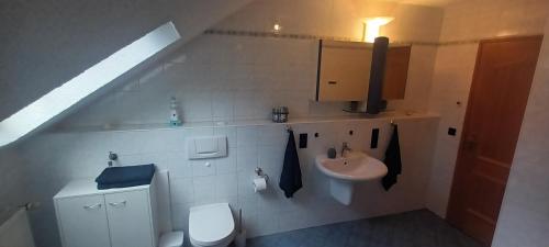 a white bathroom with a sink and a toilet at Ferienwohnung Elisabeth Waxweiler in Waxweiler