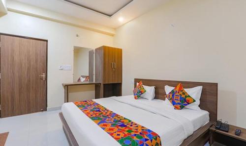 a bedroom with a large bed with colorful pillows at FabHotel The Gahmar Inn in Lucknow