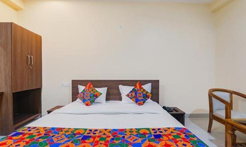 a bedroom with a bed with a colorful comforter at FabHotel The Gahmar Inn in Lucknow