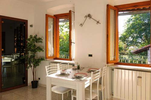 Biały stół i krzesła w pokoju z oknami w obiekcie Reggia di Venaria - Tranquillity choice - Parcheggio gratuito - Grand Maison w mieście Venaria Reale