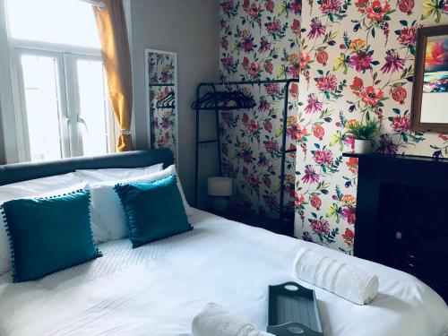 a bedroom with a white bed with blue pillows at One Bed Apartment in Windsor Town Centre, 5 min walk to the Castle!! in Windsor