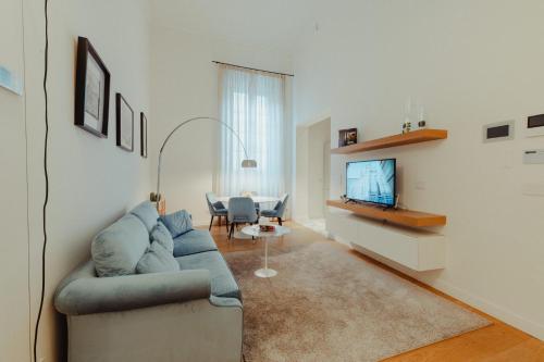 uma sala de estar com um sofá e uma televisão em Bufalini Boutique Apartment em Florença