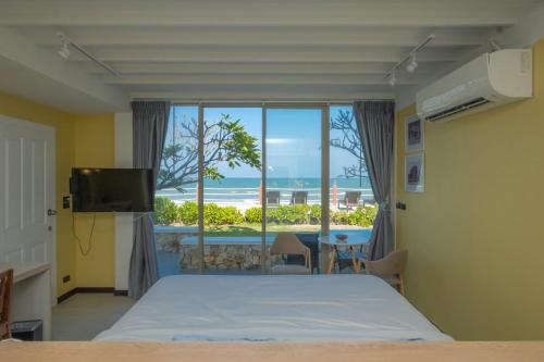 1 dormitorio con cama y vistas al océano en De Chaochom Hua Hin, en Hua Hin