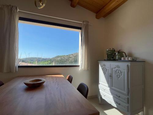 a dining room with a table and a large window at Villa Dolce Valle in Ragusa