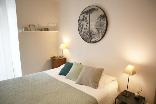 - une chambre dotée d'un lit avec une horloge murale dans l'établissement Appartement locations secrètes sarlat, à Sarlat-la-Canéda