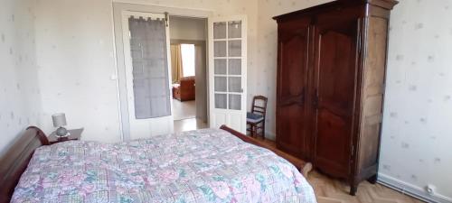een slaapkamer met een bed en een houten kast bij appartement 2 chambres in Baccarat