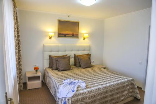 a bedroom with a bed and a painting on the wall at Dnepropetrovsk Hotel in Dnipro