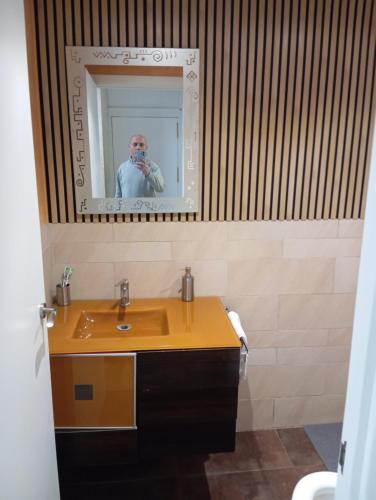 um homem tirando uma foto de um lavatório de casa de banho em Villa Juanmi em Magaluf