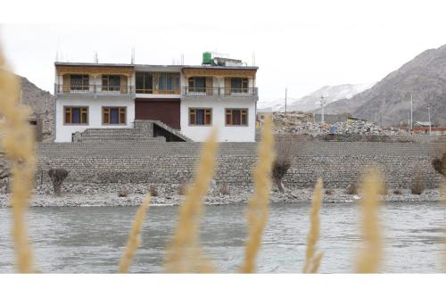 een gebouw aan de oever van een rivier bij Indus Retreat in Chimre