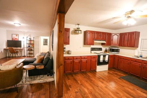 a kitchen with wooden cabinets and a living room with a couch at Modern & Cozy Getaway House near Conway lake - Pet Friendly in Conway