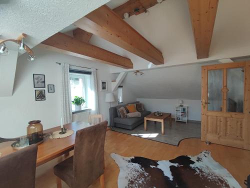 a living room with a table and a cow on the floor at Haus Schatzl mit Gartenanteil und Bademöglichkeit im Fluss in Bad Aussee