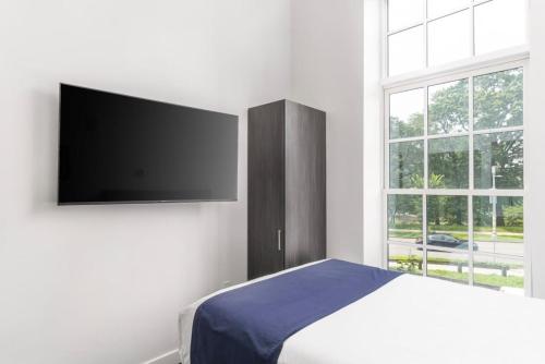 a bedroom with a bed and a flat screen tv at Stylish Studio in Historic Boston - #206 in Boston