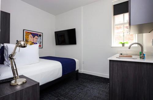 a hotel room with a bed and a sink at Modern Studio in Historic Boston - Unit #303 in Boston