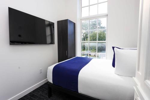 um quarto com uma cama e uma televisão de ecrã plano em Stylish Studio in Historic Boston - Unit #209 em Boston