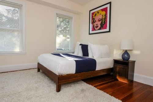 ein Schlafzimmer mit einem Bett und einem Tisch mit einer Lampe in der Unterkunft Stylish Apartment in Malden 20 Min from Boston #2 in Malden