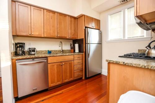 a kitchen with wooden cabinets and a stainless steel refrigerator at Stylish Apartment in Malden 20 Min from Boston #2 in Malden