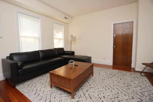 a living room with a black couch and a coffee table at Stylish Apartment in Malden 20 Min from Boston #2 in Malden