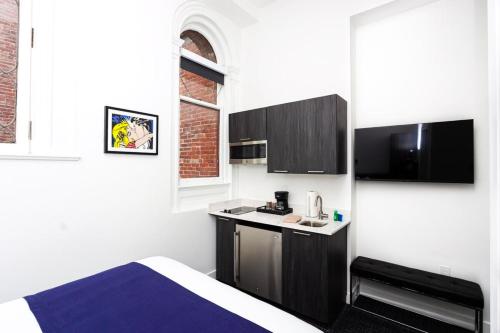 ボストンにあるStylish Studio in Fenway Neighborhood - Unit #203のベッドとキッチン付きの小さな部屋