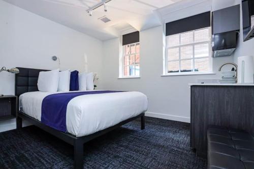 um quarto de hotel com uma cama grande e uma cozinha em Modern Studio in Historic Boston - Garden Unit #1 em Boston